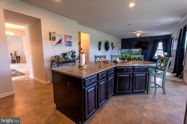 2045 Magnolia Cir, Culpeper, VA 22701 - kitchen with dark stone countertops, a center island, baseboards, a breakfast bar area, and recessed lighting