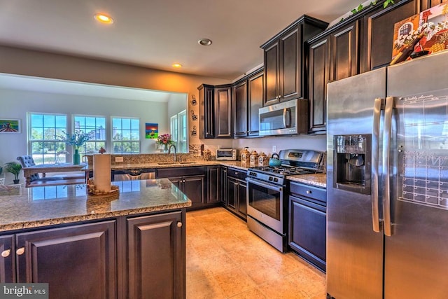 2045 Magnolia Cir, Culpeper, VA 22701 - kitchen with appliances with stainless steel finishes, dark stone countertops, recessed lighting, a sink, and dark brown cabinetry