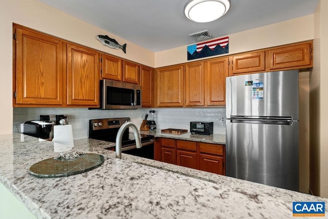 1808 High Ridge Ct, Condos, Wintergreen Resort, VA 22967 - kitchen with stainless steel appliances, backsplash, brown cabinets, light stone countertops, and a peninsula