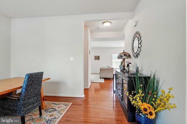 hallway featuring wood finished floors and baseboards