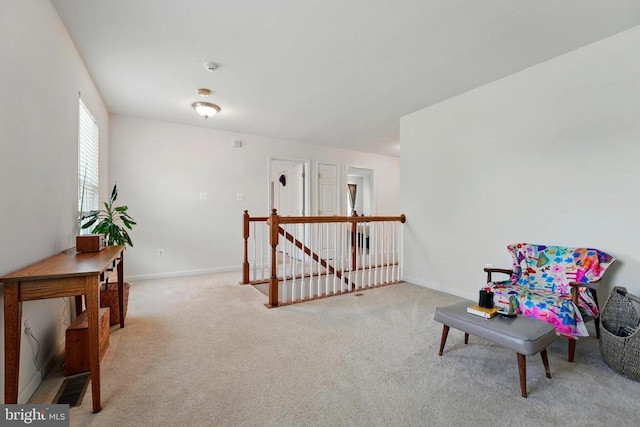 living area with an upstairs landing, carpet flooring, and baseboards