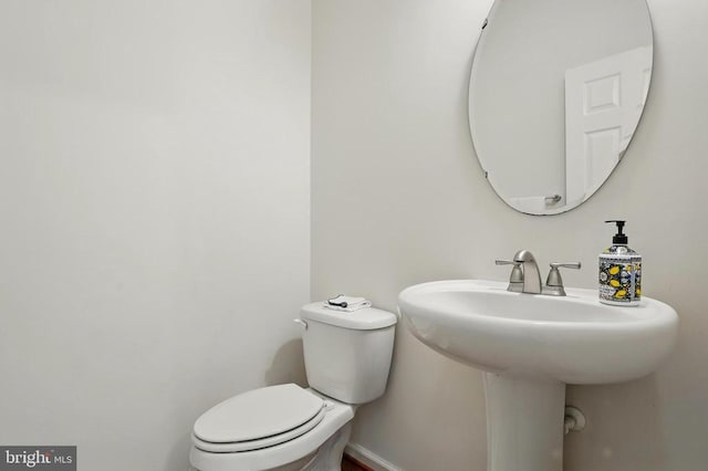 half bathroom featuring toilet and a sink