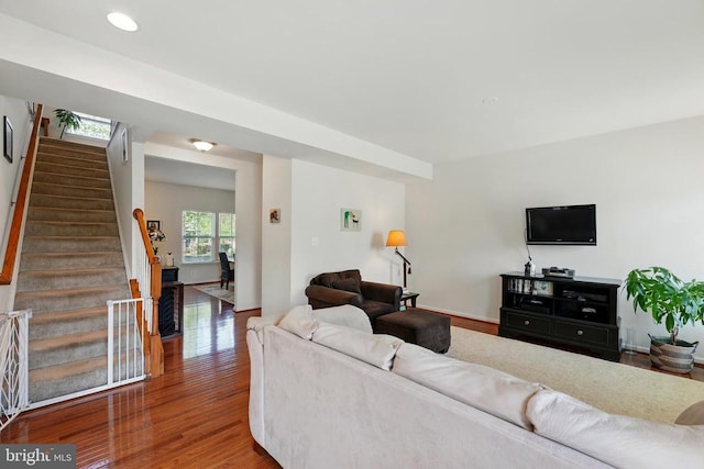 living room featuring stairway, wood finished floors, and baseboards