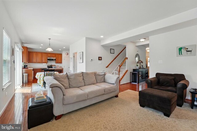 living area with recessed lighting, stairway, light wood finished floors, and baseboards