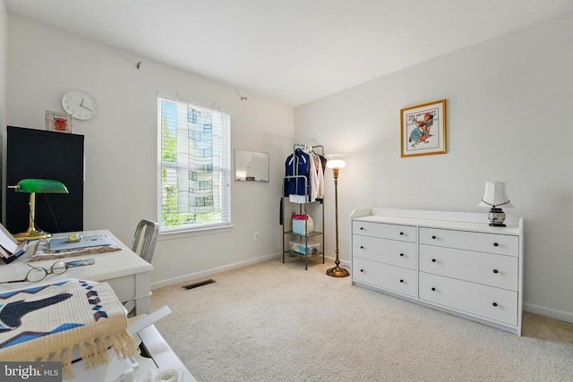 bedroom with light colored carpet, baseboards, and an office area