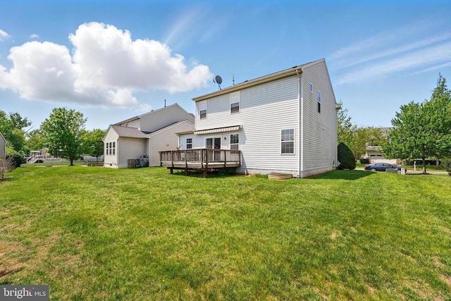 rear view of house with a wooden deck and a lawn