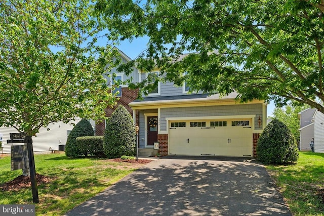 view of front facade with driveway, a garage, brick siding, and a front yard