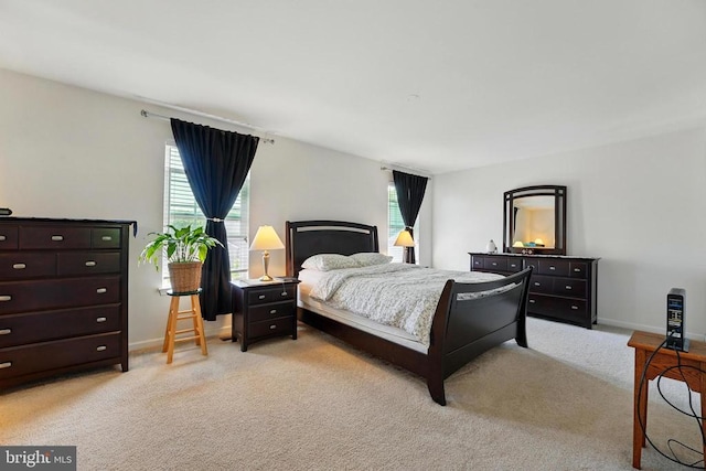 bedroom with light colored carpet and baseboards