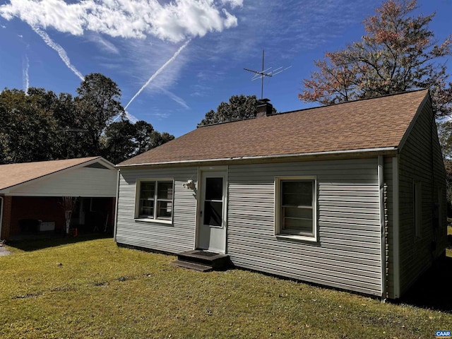 bungalow-style house featuring a shingled roof, a chimney, and a front yard