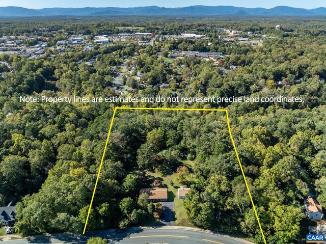 drone / aerial view with a wooded view and a mountain view