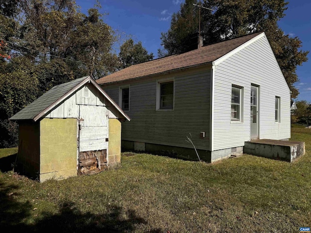 exterior space with a lawn, an outbuilding, a storage unit, and crawl space
