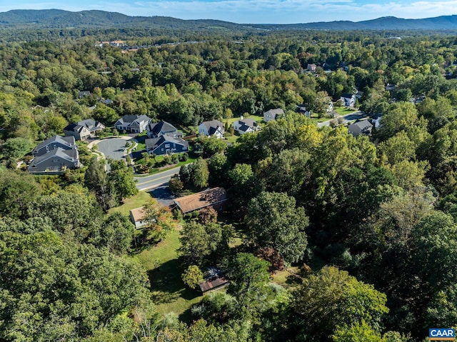 birds eye view of property with a wooded view and a mountain view
