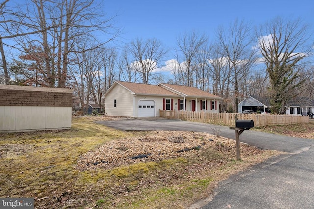 view of front of house featuring an outbuilding, fence, a garage, and driveway