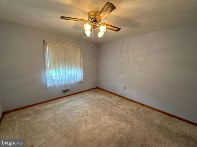 empty room featuring a ceiling fan, carpet, and baseboards