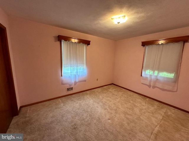 carpeted empty room with baseboards