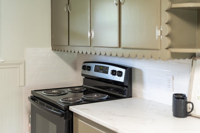 kitchen with electric range oven, decorative backsplash, and light stone countertops