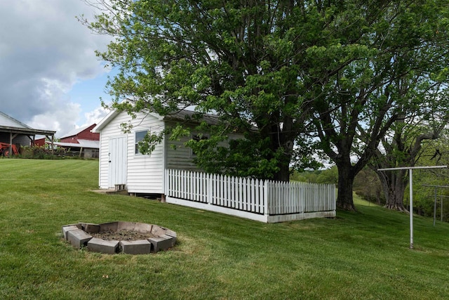 view of grassy yard featuring an outdoor fire pit