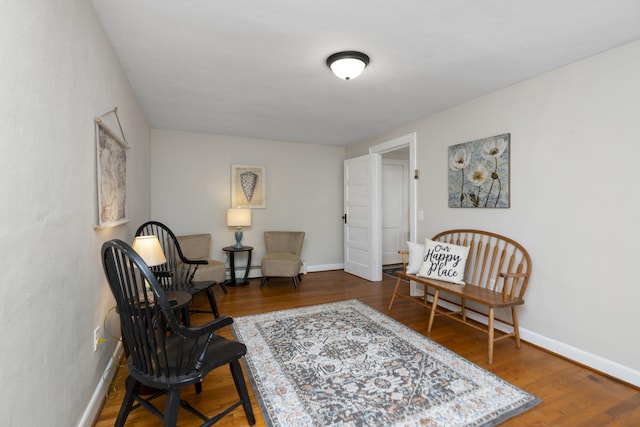 living area featuring wood finished floors, baseboards, and baseboard heating