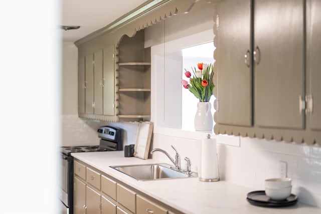kitchen featuring electric range, a sink, tasteful backsplash, and light countertops
