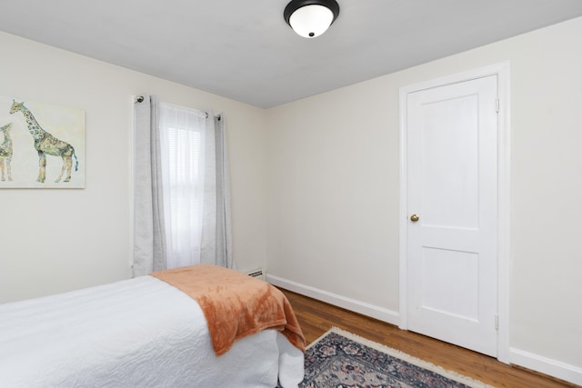bedroom with wood finished floors and baseboards