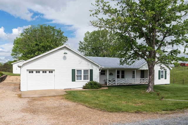 ranch-style house with covered porch, driveway, a front yard, and an attached garage