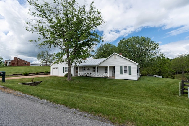 view of front of home featuring covered porch, a front lawn, a garage, and a chimney