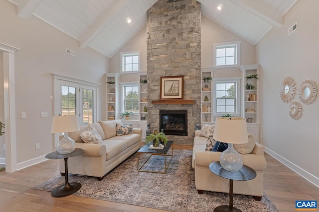 living area featuring beam ceiling, high vaulted ceiling, visible vents, and wood finished floors