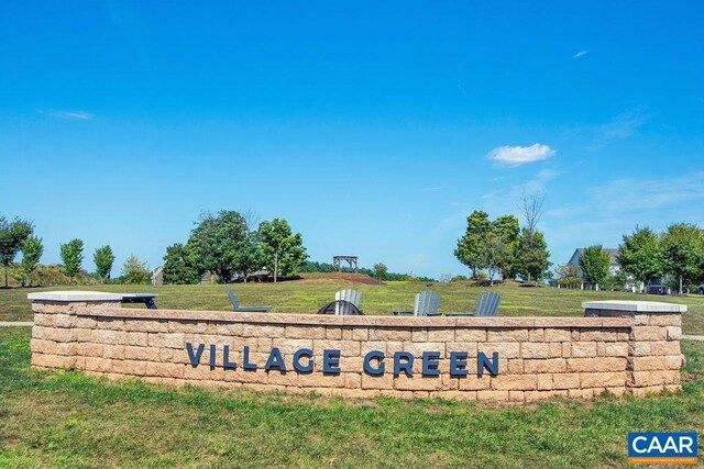 community / neighborhood sign with a yard