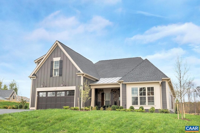 modern farmhouse featuring a garage, a front lawn, board and batten siding, driveway, and roof with shingles
