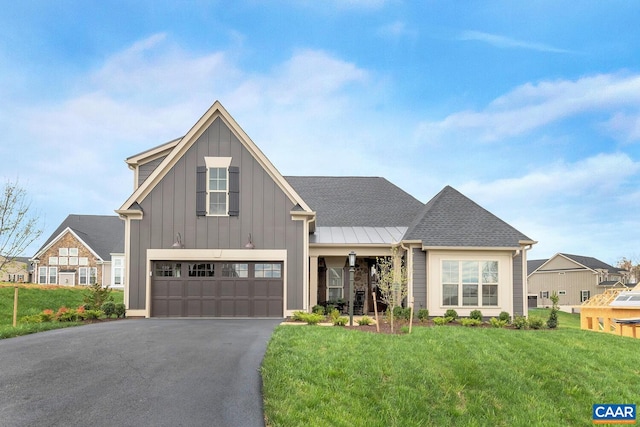 modern inspired farmhouse with board and batten siding, aphalt driveway, a front yard, and a garage