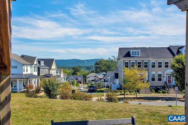 exterior space with a yard, a mountain view, and a residential view