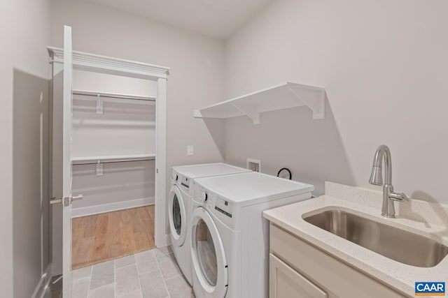 washroom featuring laundry area, separate washer and dryer, and a sink