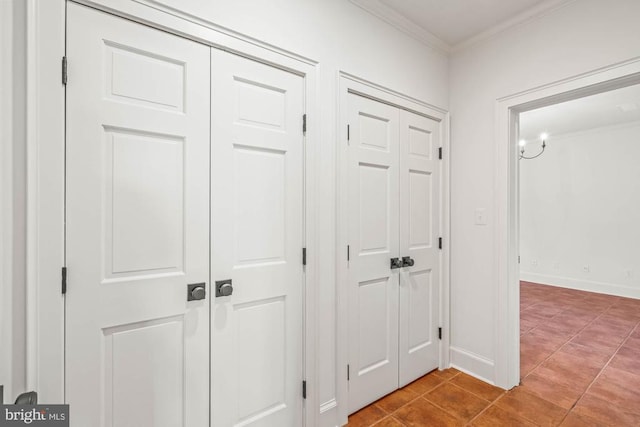corridor featuring crown molding, tile patterned flooring, and baseboards