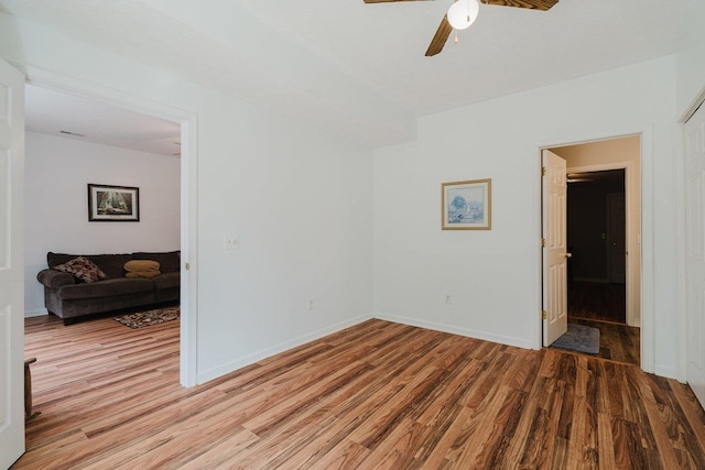 spare room featuring wood finished floors, baseboards, and ceiling fan
