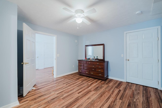 bedroom featuring ceiling fan, light wood-style flooring, and baseboards