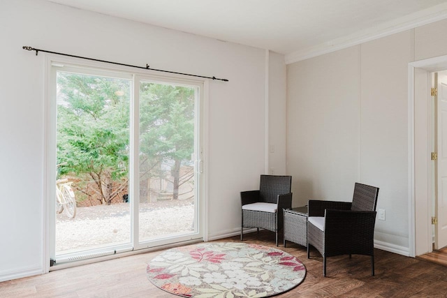 sitting room with crown molding and wood finished floors