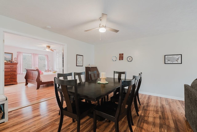 dining space featuring baseboards, a ceiling fan, and wood finished floors