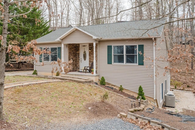 ranch-style house featuring central AC unit and a shingled roof