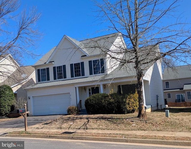 traditional-style home with asphalt driveway, a garage, and a shingled roof