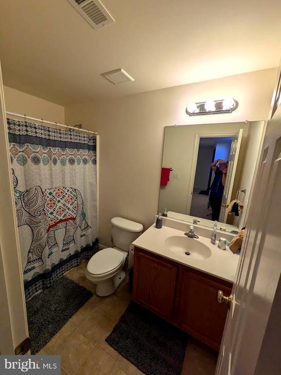 full bathroom featuring vanity, tile patterned flooring, toilet, and a shower with shower curtain