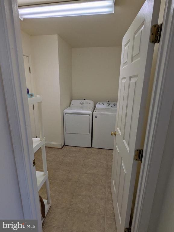 washroom with independent washer and dryer and light tile patterned floors