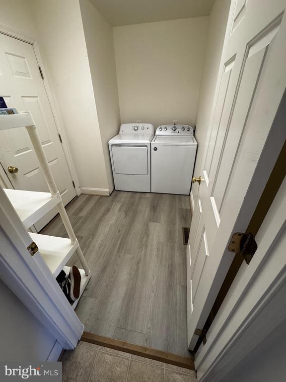 laundry room featuring independent washer and dryer, wood finished floors, and baseboards