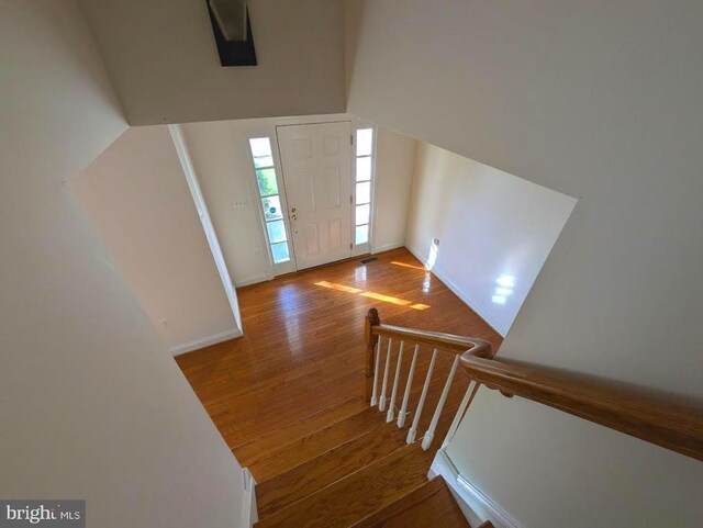 staircase featuring wood finished floors and baseboards