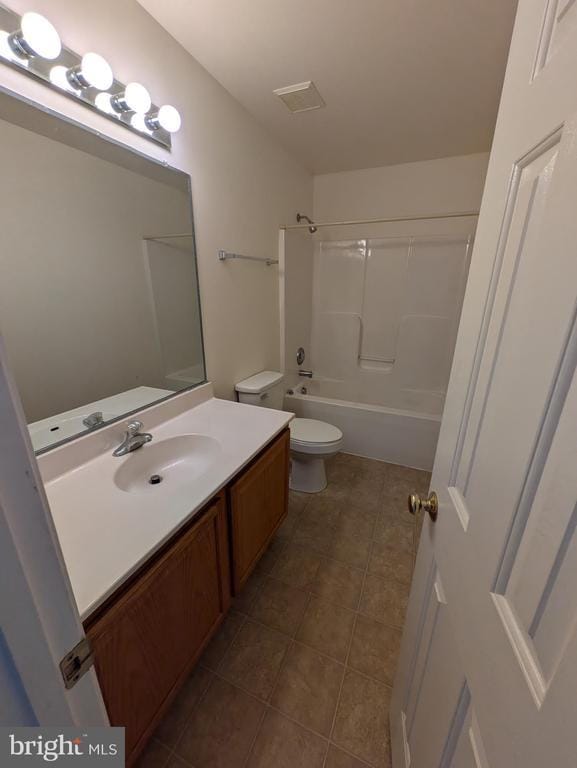 bathroom featuring tile patterned flooring, toilet, vanity, and washtub / shower combination
