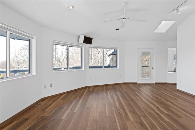 interior space featuring a skylight, visible vents, plenty of natural light, and wood finished floors