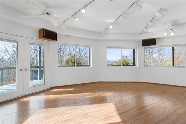 spare room with a wealth of natural light, light wood-style floors, ceiling fan, and track lighting