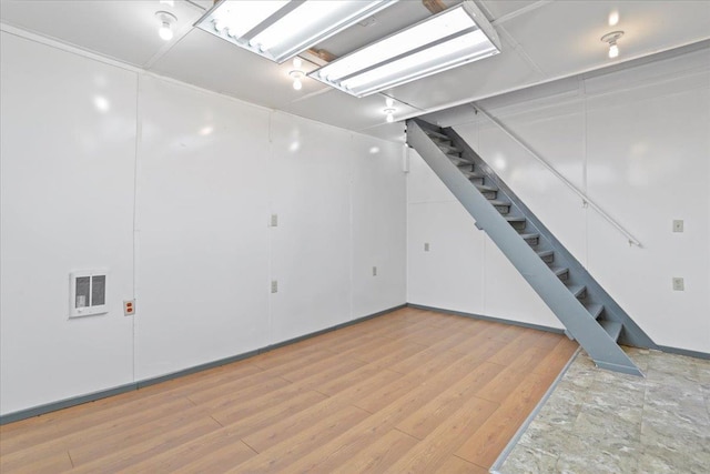 basement featuring stairs, light wood-style flooring, and visible vents