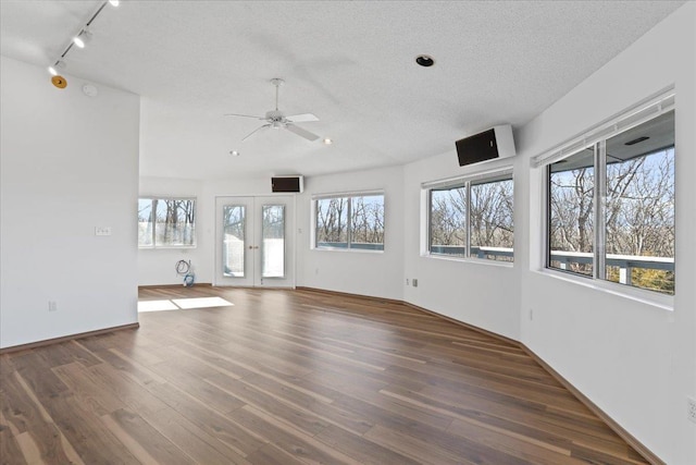 interior space with wood finished floors, a ceiling fan, rail lighting, a textured ceiling, and recessed lighting