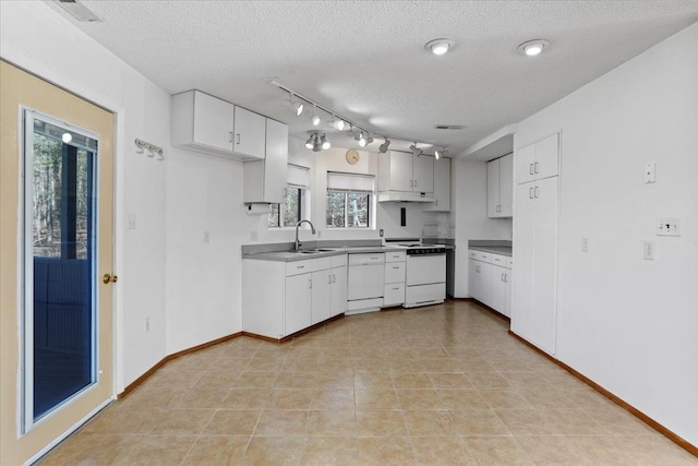 kitchen featuring a sink, white cabinets, rail lighting, a textured ceiling, and white appliances