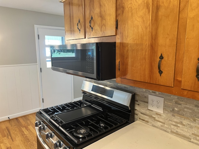 2516 Sharlaine Dr S, Staunton, VA 24401 - kitchen view of stainless steel appliances, brown cabinets, a wainscoted wall, light countertops, and backsplash